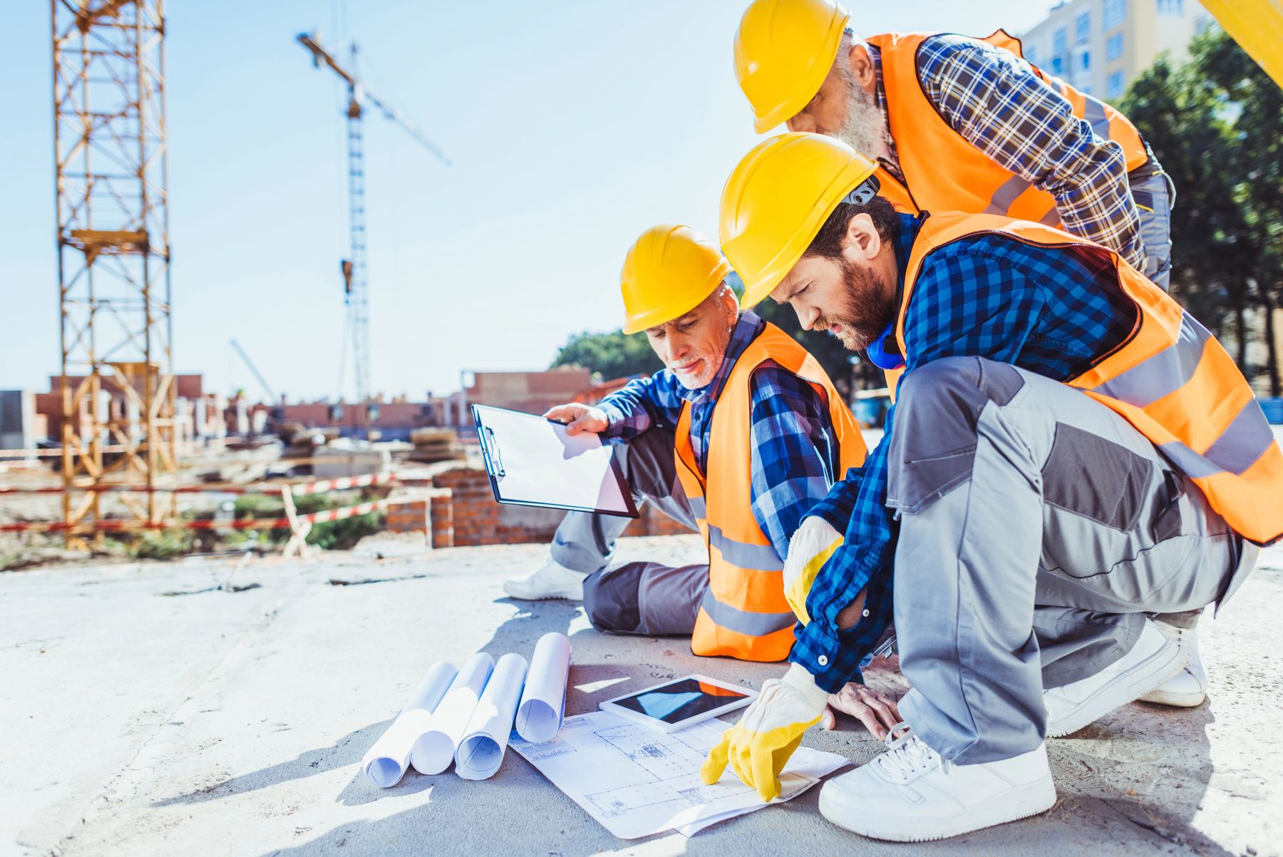 Construction team reviewing building plans on site